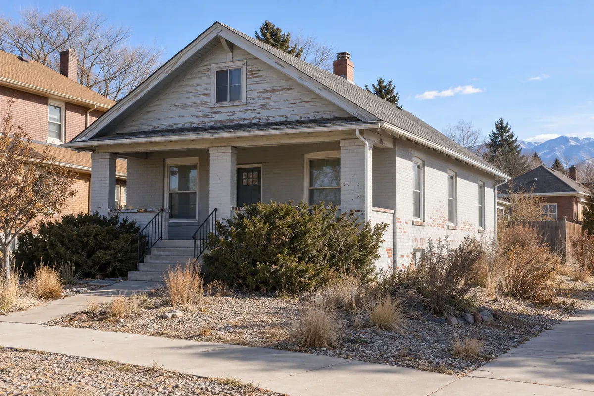 A house with peeling paint and worn roof shingles that needs repairs